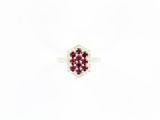 un gros plan d'une bague sertie d'un diamant rouge et blanc sur une surface blanche