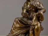bronze statue of a woman holding a child on her lap