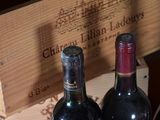 two bottles of wine sitting in a wooden box