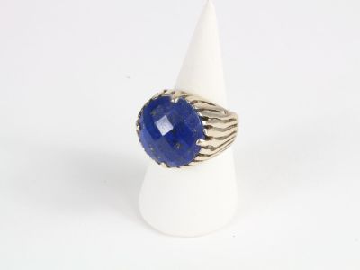 a close up of a ring with a blue stone on it