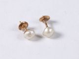 a pair of pearl earrings on a white surface