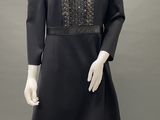 a mannequin wearing a black dress and black shoes
