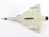 underside view of a model of a fighter jet on a white surface