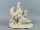 une statue représentant un coq et une poule posée sur une table