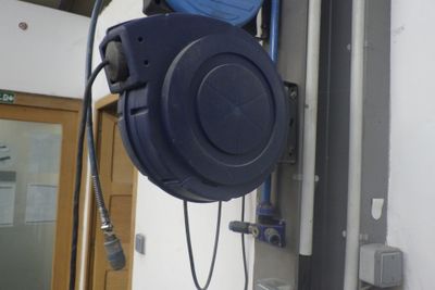 un tuyau bleu suspendu au mur d'un immeuble