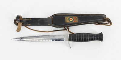 a knife and a sheath on a white surface