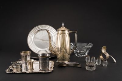un plateau en argent et des couverts en argent posés sur une table noire