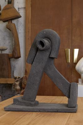 une statue représentant un homme assis sur une table, à côté d'une autre statue représentant un homme