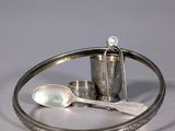 a silver plate with a spoon, spoon and spoon rest on it