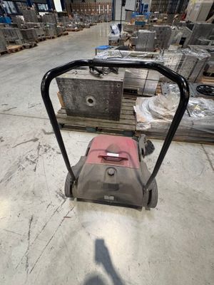 a red and black lawn mower in a warehouse