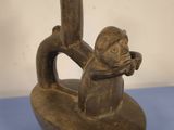 an old wooden figurine with a monkey on it ' s back