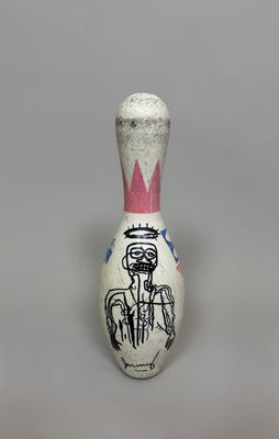 a small white and pink bowling pin with a picture of a man on it