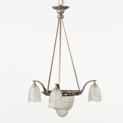 un lustre ancien en laiton avec des abat-jours en verre dépoli