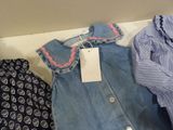 a lot of clothes that are sitting on a shelf