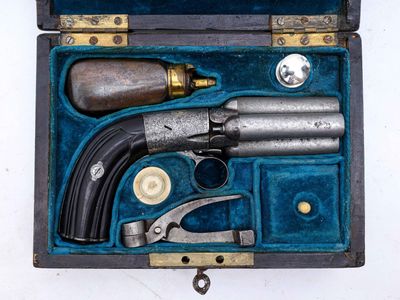 une vieille arme à feu dans un coffret contenant d'autres objets