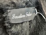 a close up of a black teddy bear with a label on it