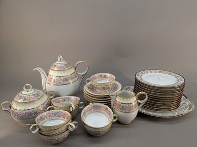 plusieurs assiettes et tasses et une théière sur la table