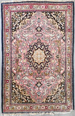 un tapis persan ancien orné d'un motif en médaillon sur fond rose