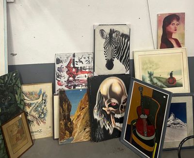 de nombreux tableaux accrochés au mur d'une pièce où se trouve un vélo