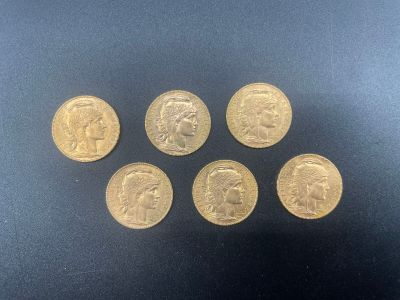 six gold sovereigns, one of which has a head of a man and five of which are of different