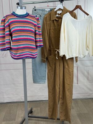 three pieces of clothing are hanging on a clothes rack in a room