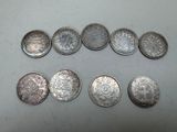 six different types of silver coins laid out on a table