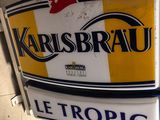 a yellow and white sign that says karlsbrau le tropic