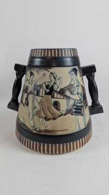 a vase with a painting on it sitting on a table