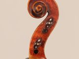 an antique violin with a scroll on the back of it