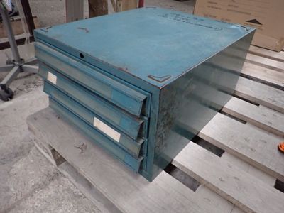 une boîte bleue posée sur une palette, elle-même posée sur une autre palette