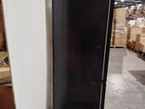 a black refrigerator sitting in a warehouse with boxes