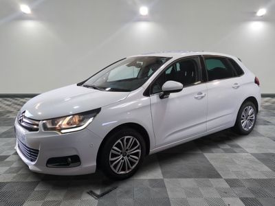 une voiture blanche est garée sur le sol à carreaux d'un garage
