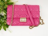 pink quilted handbag with chain strap on white background