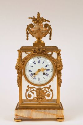 a gold clock that is sitting on a white surface