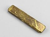 an old gold bar is sitting on a white surface