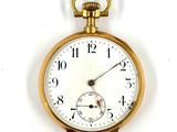 a close up of a pocket watch on a white surface