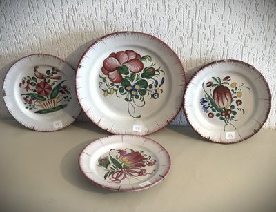 quatre assiettes ornées de fleurs, posées sur une table