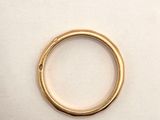 a close up of a gold ring on a white surface