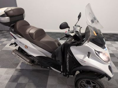 un scooter garé sur un sol à damier