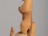 a wooden sculpture of a bear and a bear cub sitting on a rock