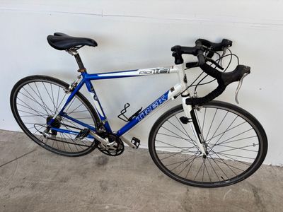 un vélo bleu et blanc appuyé contre un mur blanc