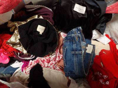 une pile de vêtements posée sur un lit