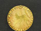 a close up of a gold coin on a black surface