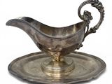 a silver plate with a saucer and a spoon on it