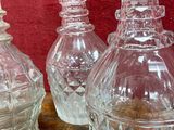 three clear glass vases sitting on a wooden table