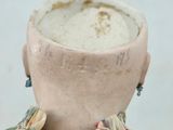 a close up of a doll ' s head on a table
