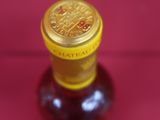 a bottle of wine that is sitting on a red surface