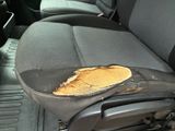 the seat of a car with a piece of wood sticking out of it