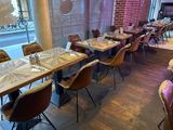 des tables et des chaises dans un restaurant, avec un mur en briques en arrière-plan