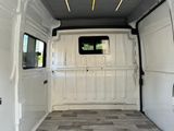 a white van with a door open and a bed in the back of it